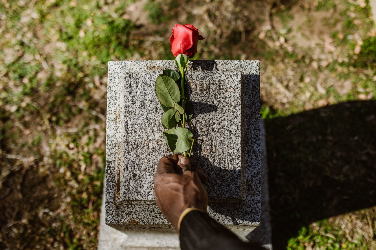 Hand of Person Putting Rose on Grave